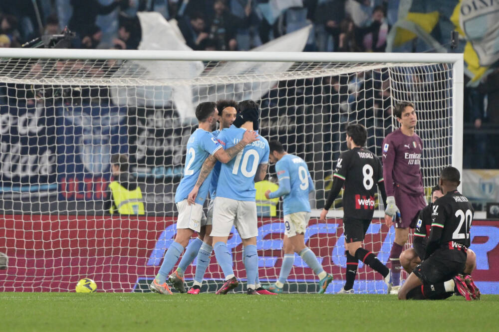 I giocatori della Lazio esultano, i rossoneri in ginocchio